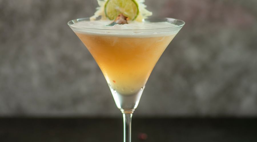 a glass of yellow drink - polo floatel kolkata