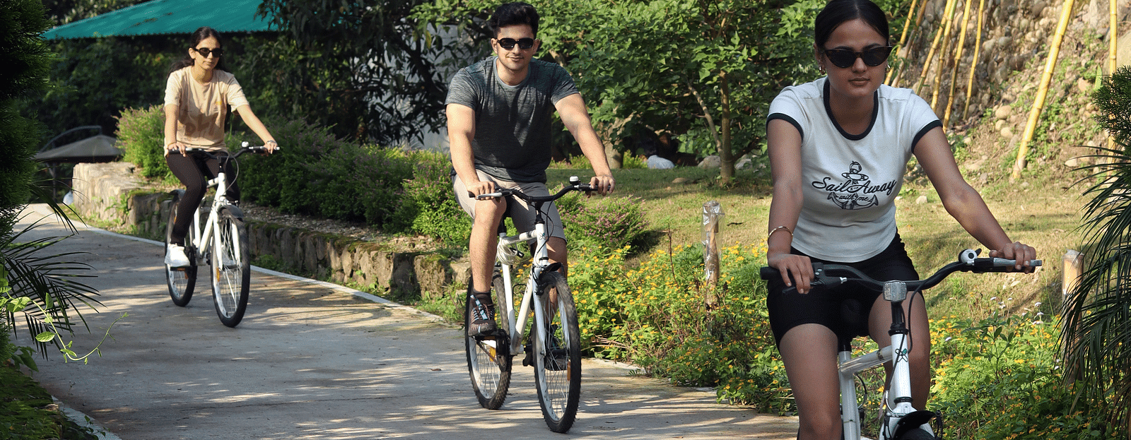 A group of people cycling on a pathway at A man flying a kite at The Sylvan Retreat, Dehradun.