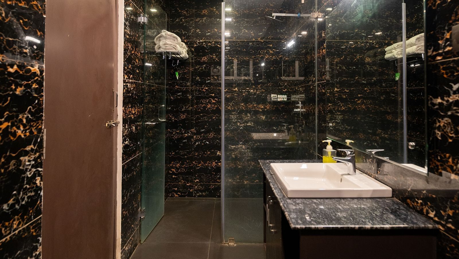 Image of a washroom with a separate shower area and a sink at Parampara Resort & Spa, Kushalnagar.