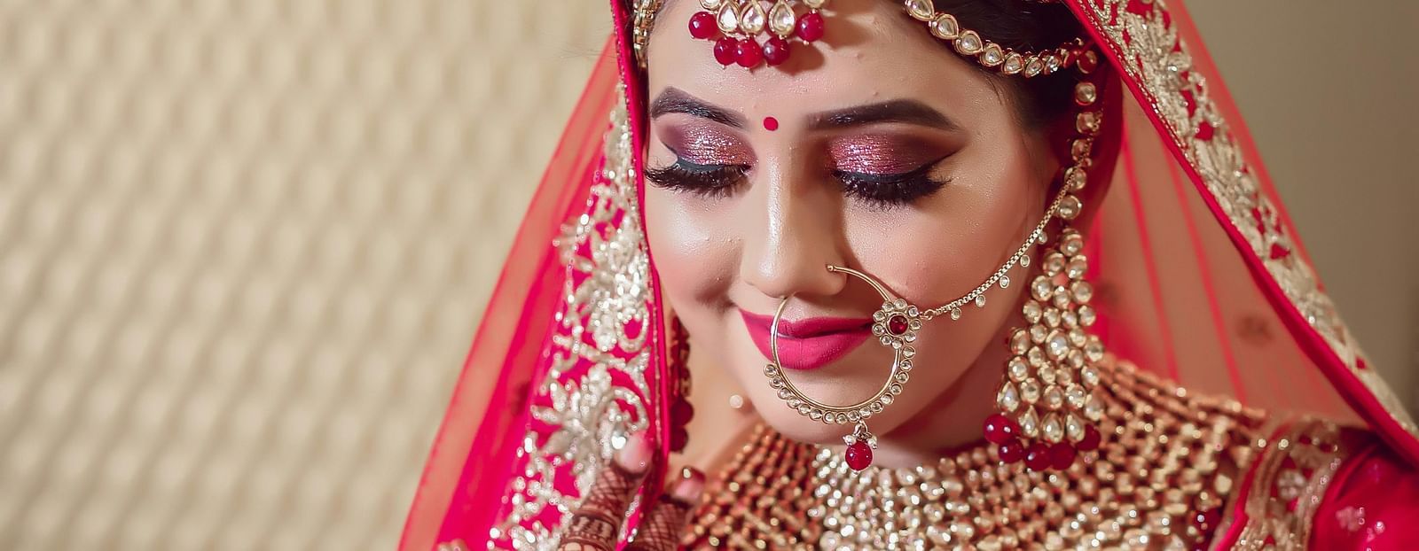 An image of a women, wearing a traditional dress with bangles and jewellery.