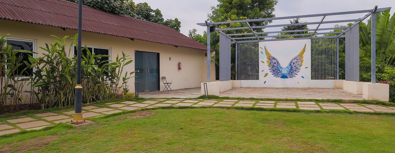 A facade image of a lawn with a logo of the resort - Trance Veechika Resort, Vikarabad