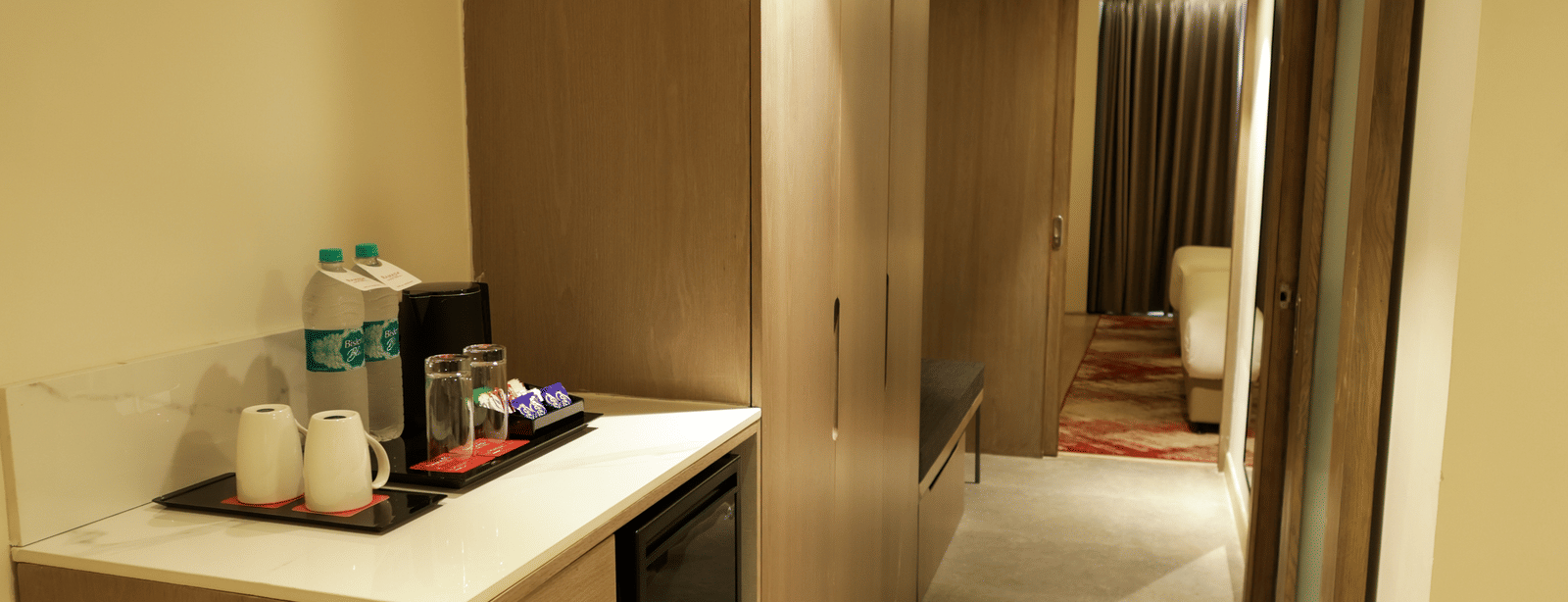 Modern room entryway with well-lit vanity and refreshments station at Ramada by Wyndham Sonipat Murthal