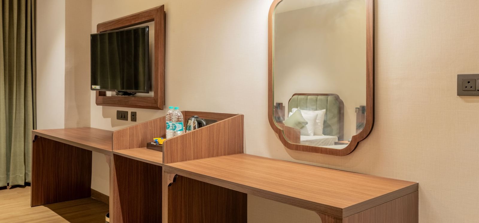 Stylish room with a dressing table, mirror, and wooden furnishings under soft lighting at Hotel Highway King, Neemrana.