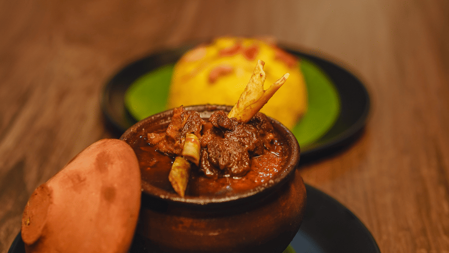 A mutton dish served in an earthen pot with yellow rice at Dip Holidays.