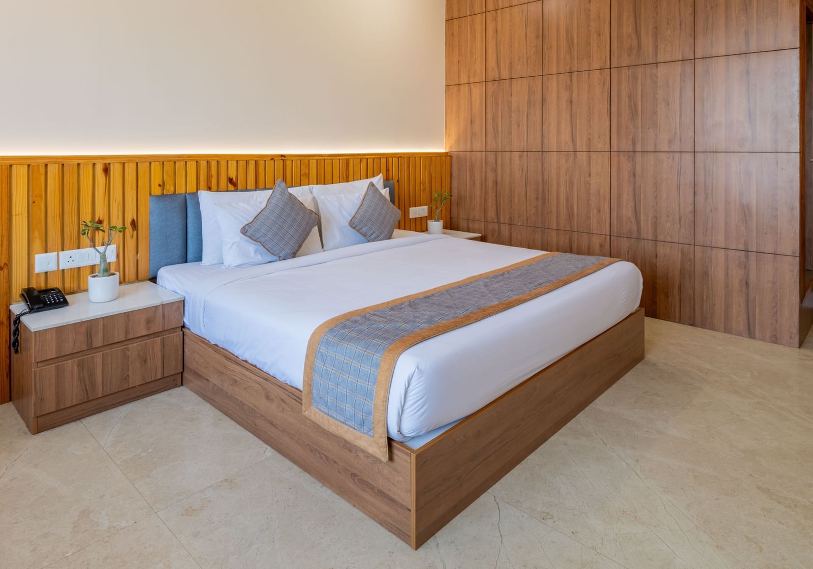Deluxe room with wooden interiors, a king size bed, and a ceiling fan at Hotel Highway King, Bagru