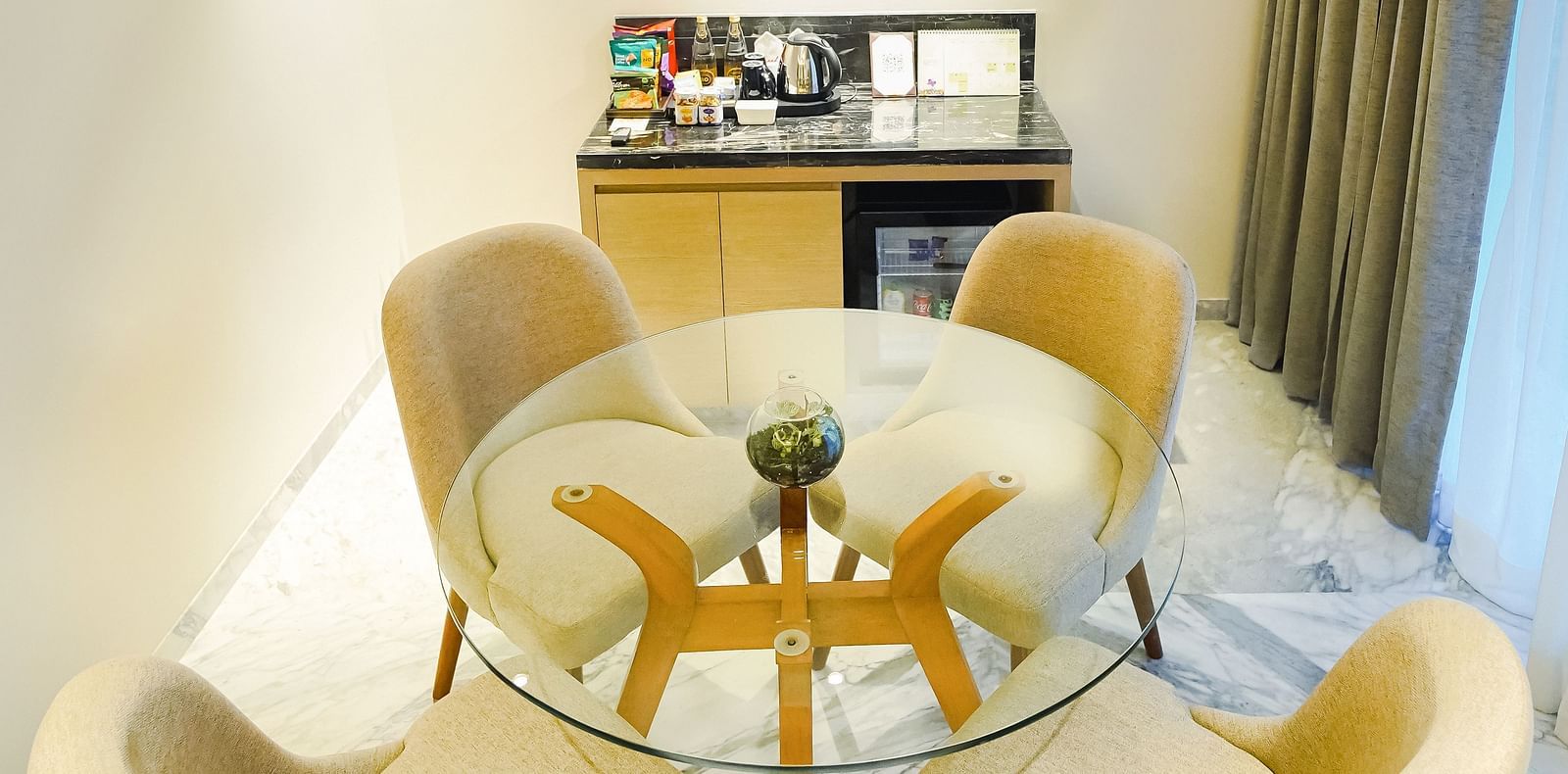 An image of the coffee table with chairs placed around it in our Deluxe Suite