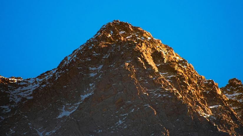 a himalayan mountain in view with blue sky in the background