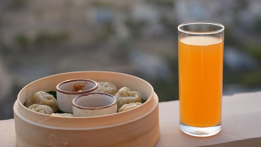 A pan-asian dish kept on the ledge with a glass of juice - Rhythm Gurugram