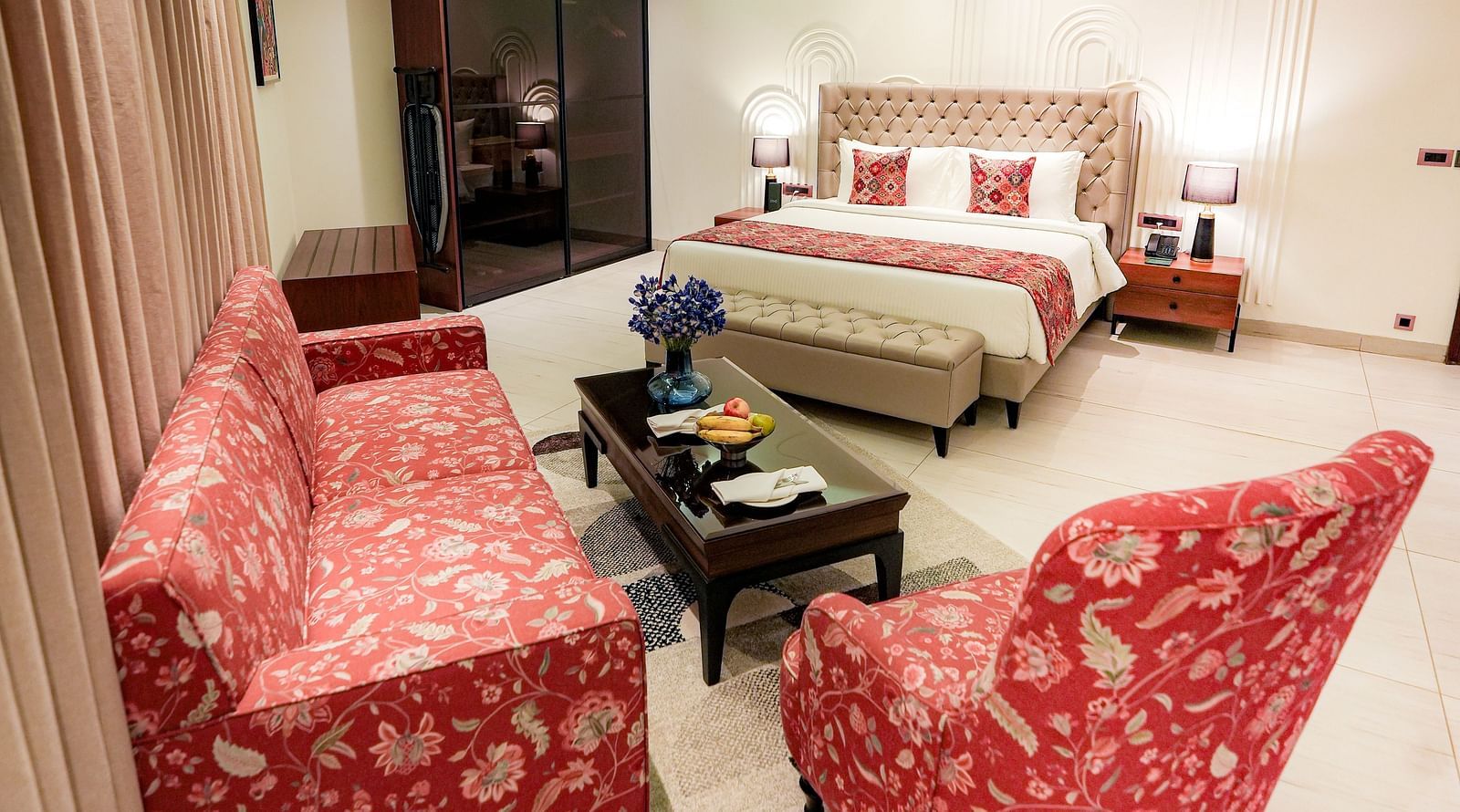 A portrait image of a suite with a upholstered chair, a upholstered sofa, a teapoy and a queen size bed - NAMAMI BY ZENQ BANKHANDI