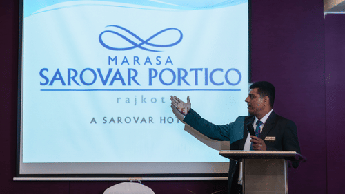  A man presenting the at banquet hall in Marasa Sarovar Portico, Rajkot
