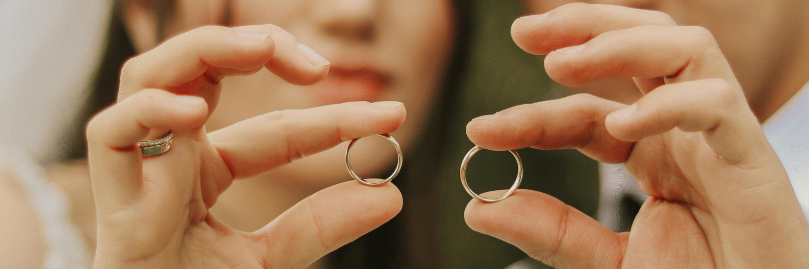 Image of newlyweds holding up wedding rings