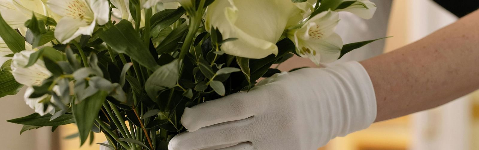 a maid arranging white flowers in a glass vase