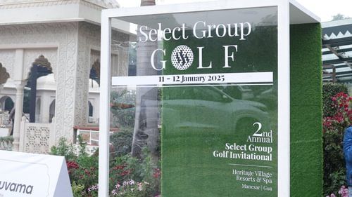 A golf sign stands prominently, framed by a white border, advertising a select group golf event . - Heritage Village Resorts & Spa