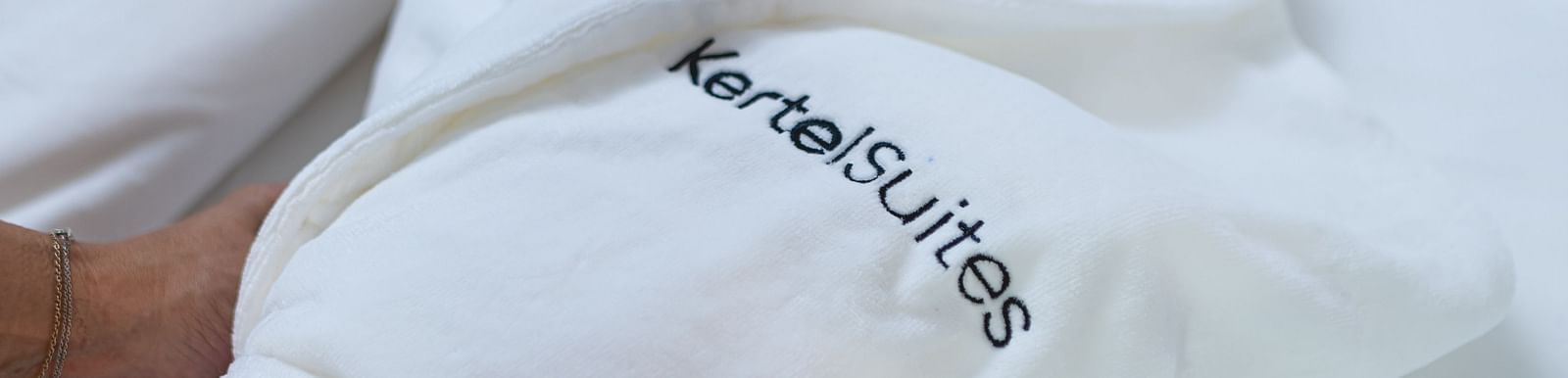 image of a white coloured towel being wrapped with Kertel Suites written on it