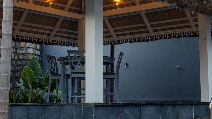 image taken from a lower angle featuring the swimming pool and the outdoor seating area under the gazebo at the luxury villa - Darza Resorts