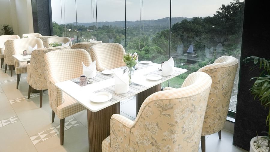 A portrait shot of a dining arrangement near floor-to-ceiling windows, offering stunning views - NAMAMI BY ZENQ BANKHANDI