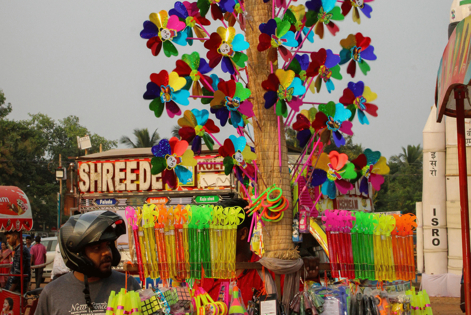 image of a roadside vendor selling hand fans for kids on his cycle