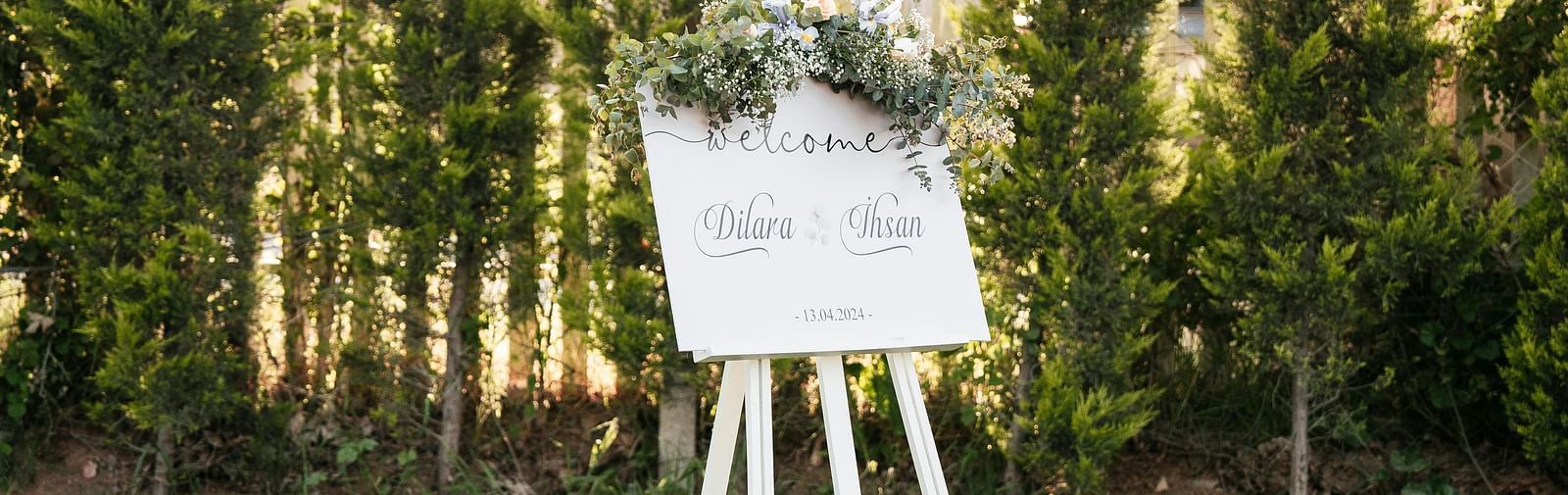 Easel setup on a green lawn surrounded by trees.