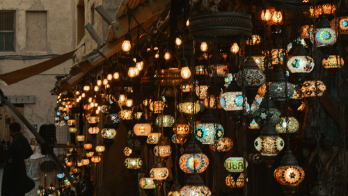 Display of vibrant Turkish lamps glowing outside a shop in a souq.