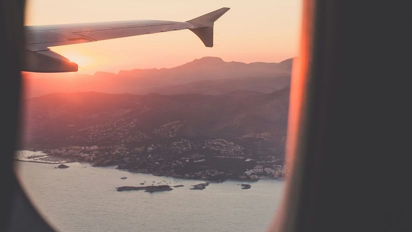 A beautiful sunset view from an airplane window, with vibrant colors painting the sky.