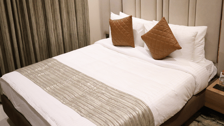 A cosy double bed is tucked neatly beside a stylishly patterned headboard wall - Lords Inn Sangam, Bhopal