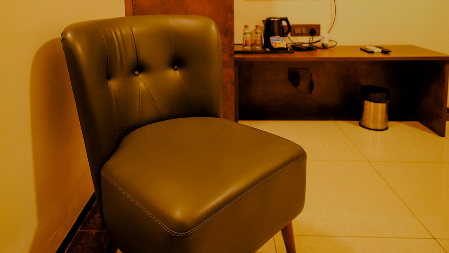 A comfortable chair in a room along with the flat screen TV at Nirantara Resort & Spa