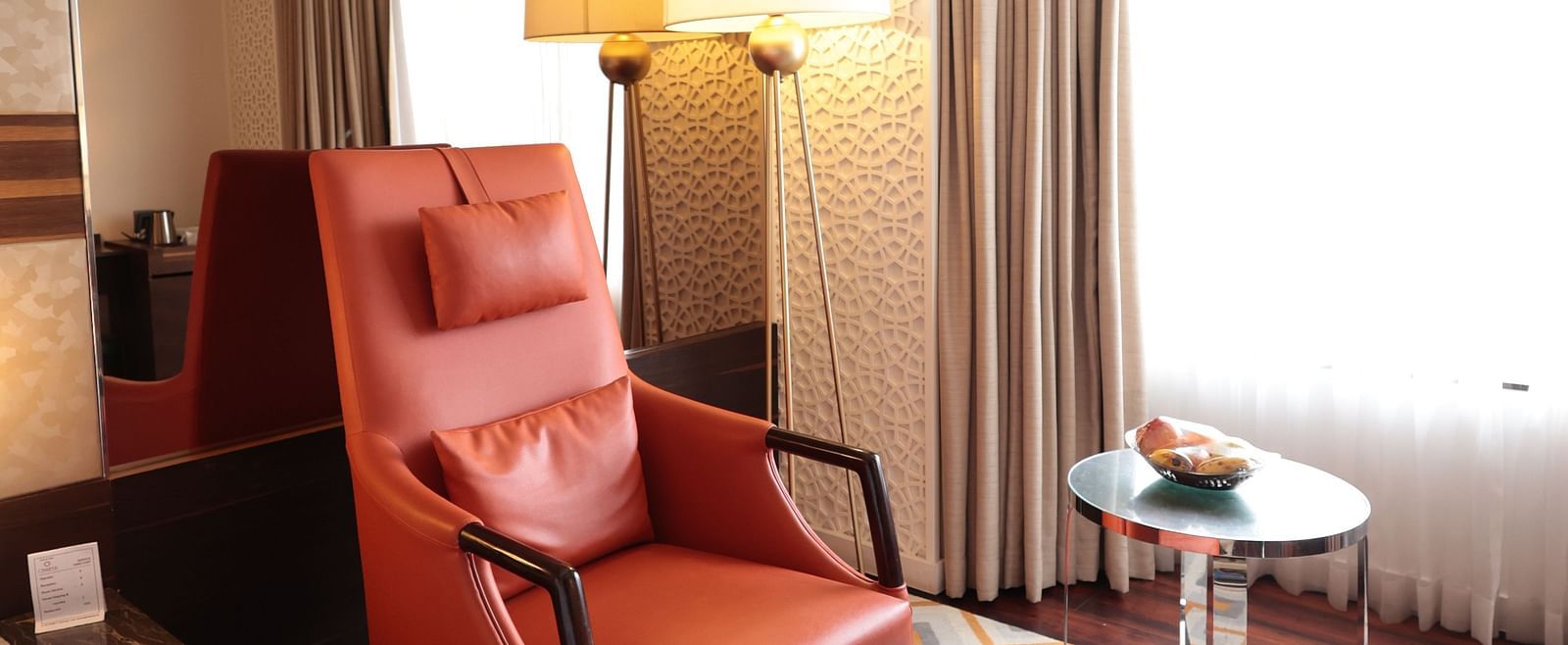 A cushioned chair with a small cushioned table in front of it | Cenneys Gateway