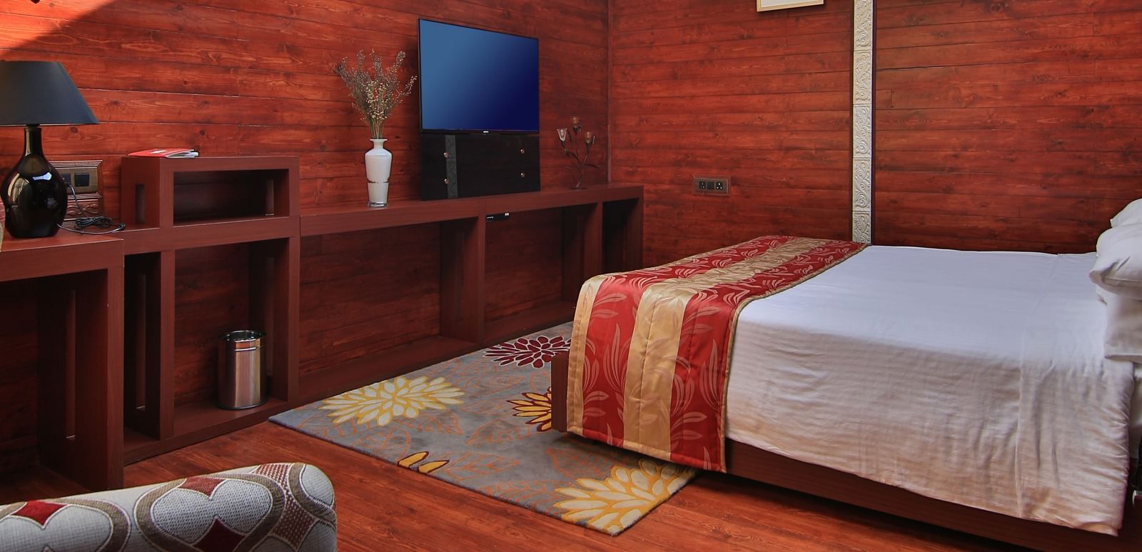 A portrait of a room in Ooty featuring a bed, wooden ascents, and a glass roof that allows sun light - Accord Highland Ooty