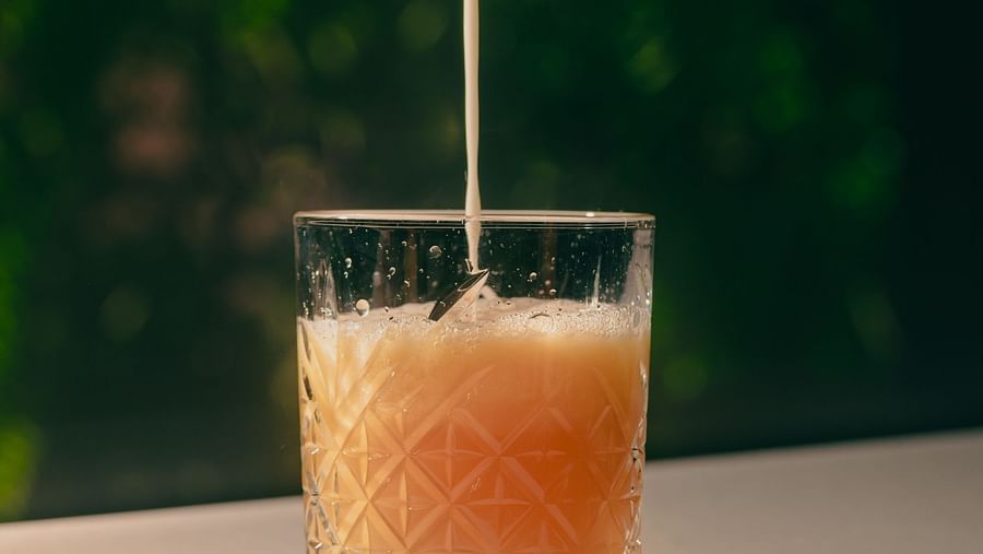 Someone pouring liquid into a cocktail glass, creating a refreshing drink.