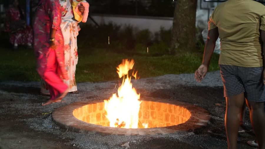 A portrait shot of the bonfire at the WOW Naturefull Resorts with a group of people surrounding it during the late evening.