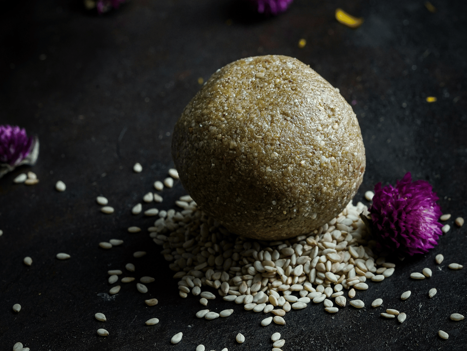 A view of a sweet dish prepared during Pongal. It is kept on a black surface with other things.