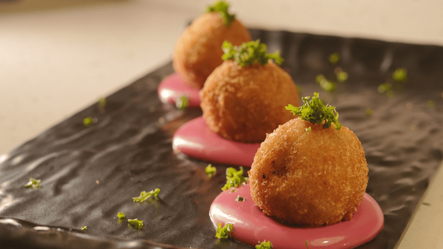 Gourmet appetizer served with colourful garnish on a black slate plate
