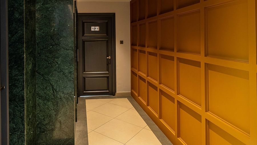 A hotel corridor near a lift illuminated by bright lights