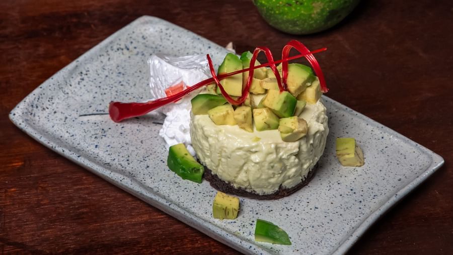 A plated dish garnished with red pepper strips and herbs, presented on a rectangular white plate. 