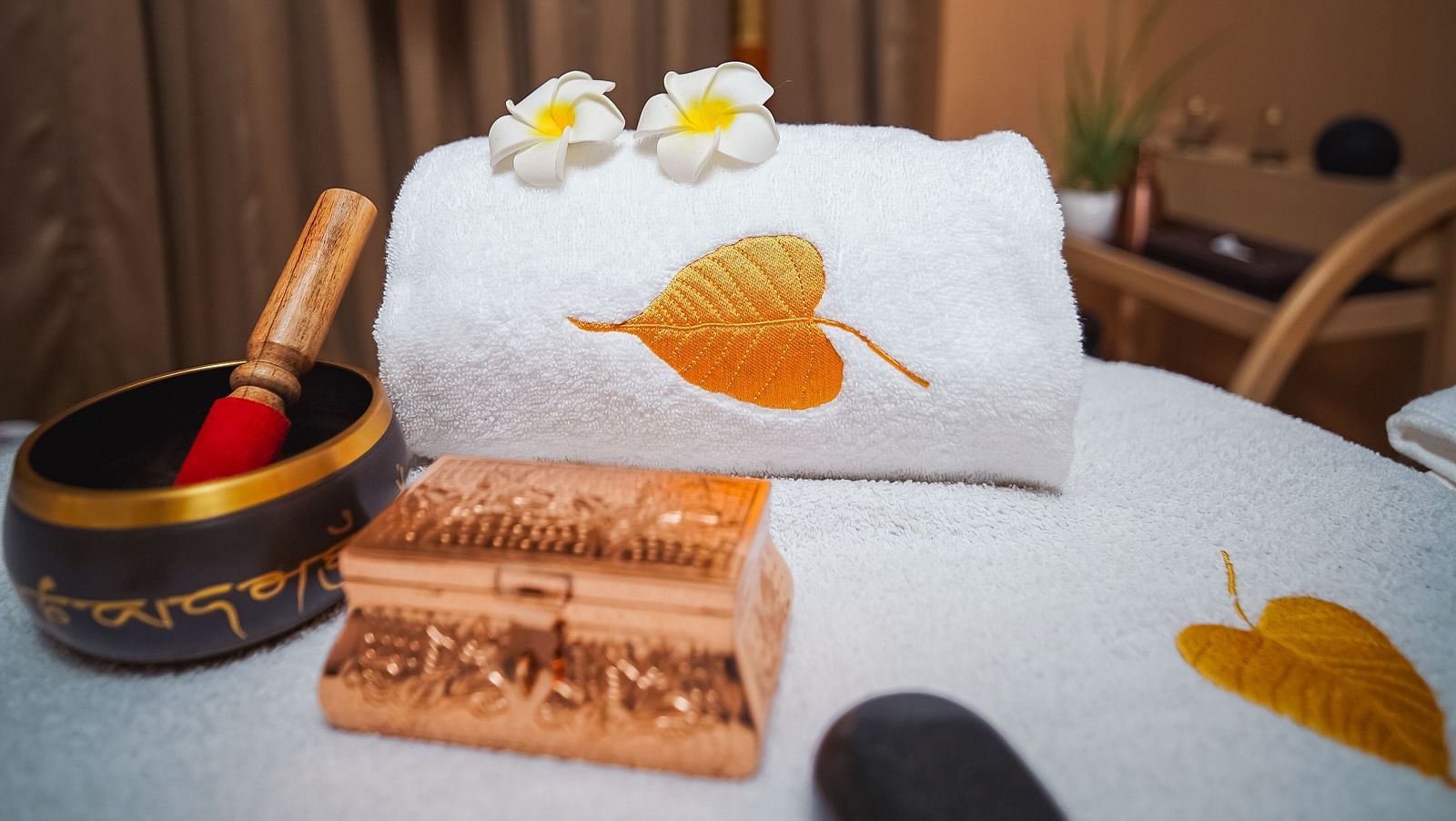 A detailed close-up of a bed adorned with items typically used during a spa treatment - Grand Madurai by GRT Hotels