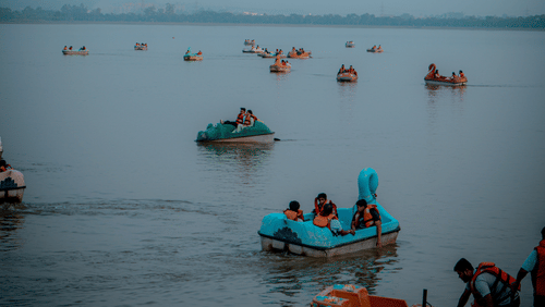 An image of Sukhna Lake with people enjoying boating on a gloomy day