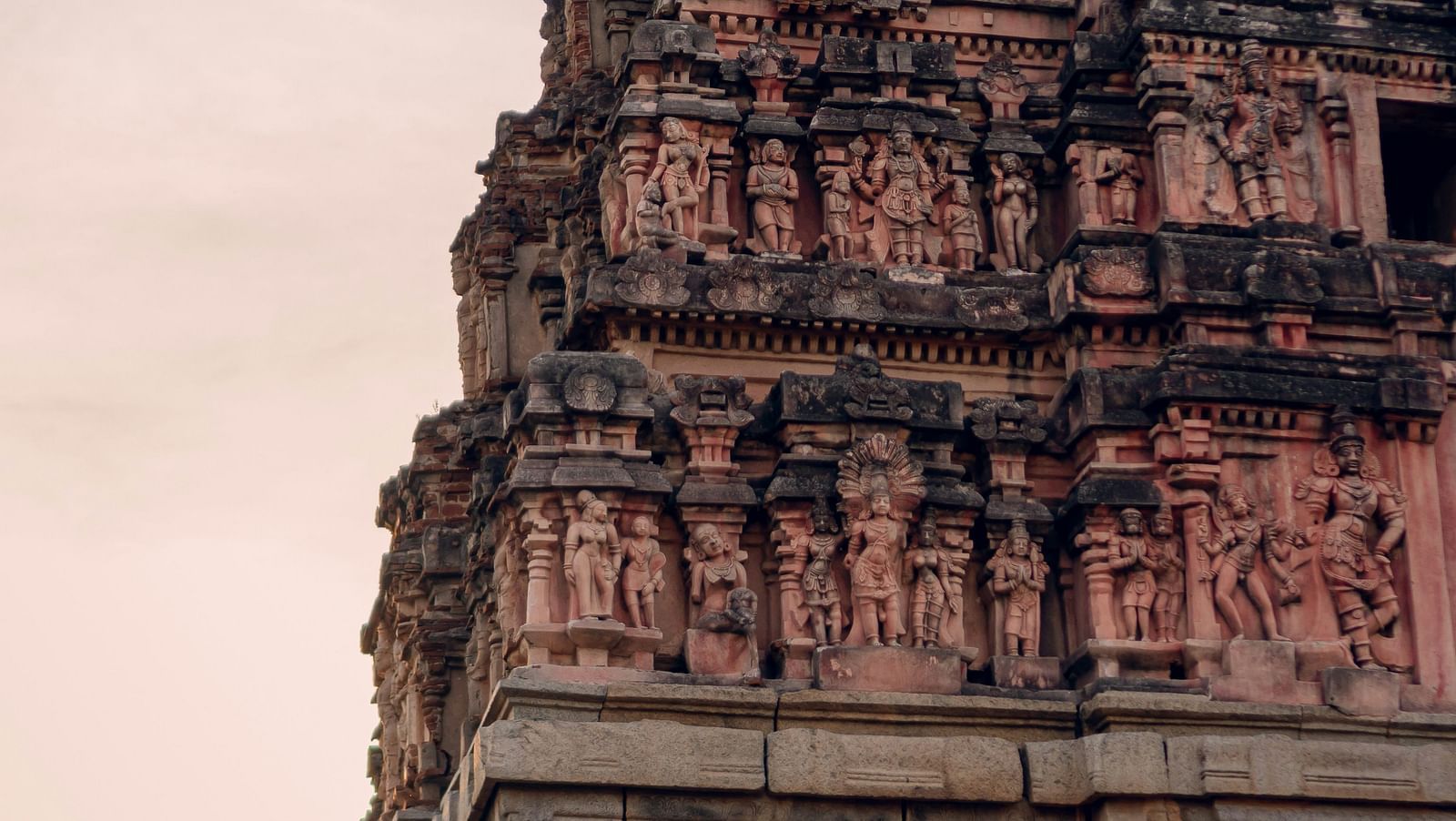 Ancient temple tower with ornate carvings against a dusky sky.