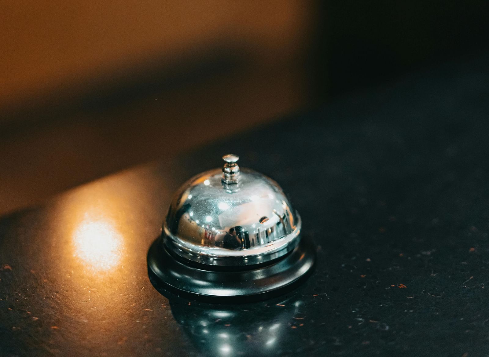 Close-up of a bell on a hotel reception desk.