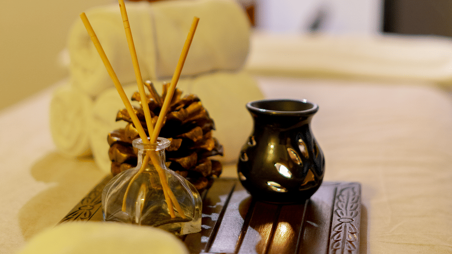 Close-up of folded white towels, pine cones, and incense sticks used for aromatherapy - Johnson Lodge & Spa, Manali