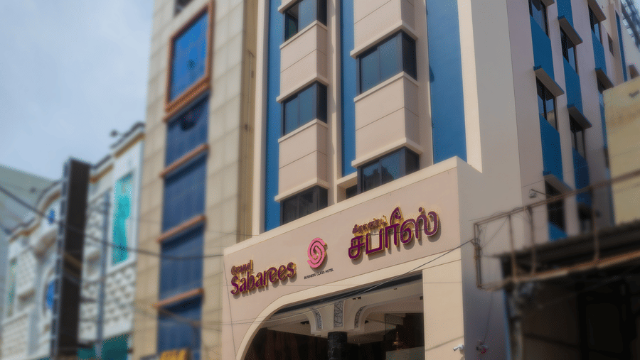 Exterior view of Hotel Grand Sabarees Madurai building showing the main entrance driveway and upper floors.