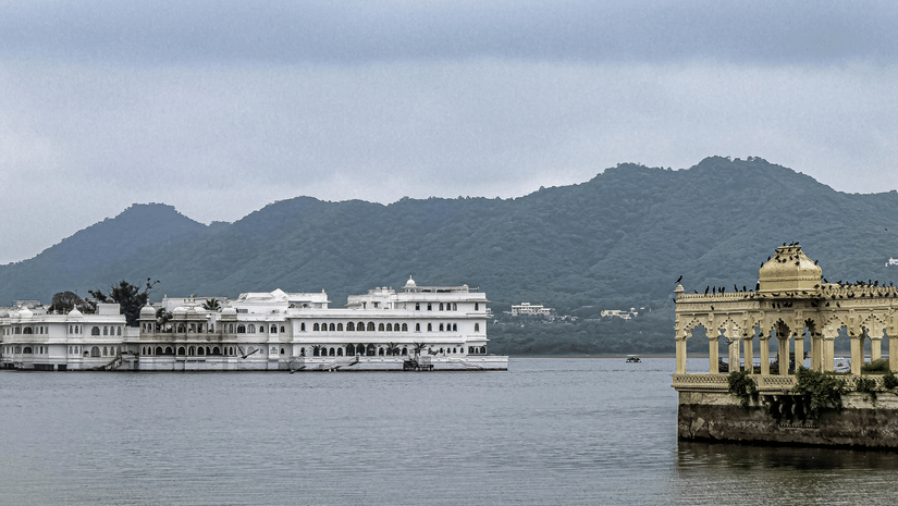 A view of Jal Mahal with the mountains in the backdrop on a cloudy day