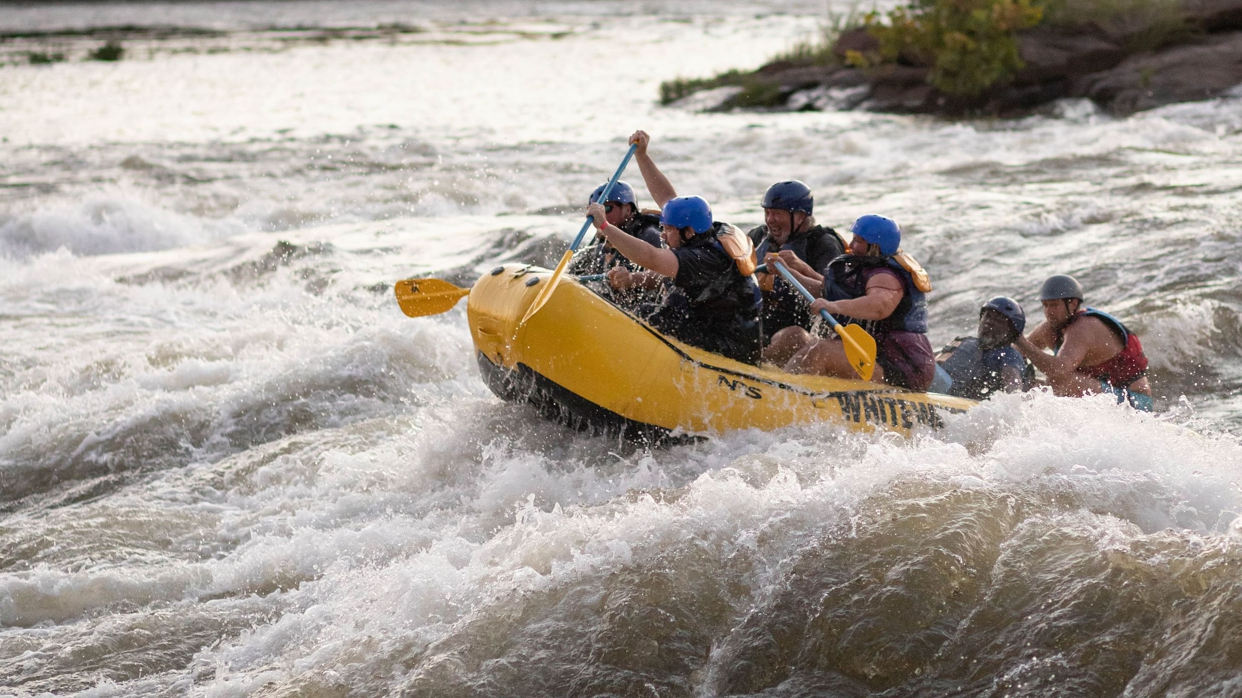 A group of people kayaking on a boat in the middle of a river at Lamrin Ucassaim Hotel, Goa