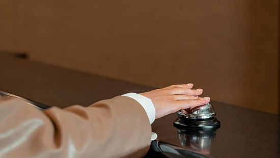 A close up shot of a person ringing the concierge bell