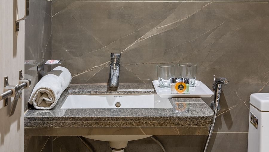 Mirror and a sink at Luxury Premium Room at Hotel Meghdoot 