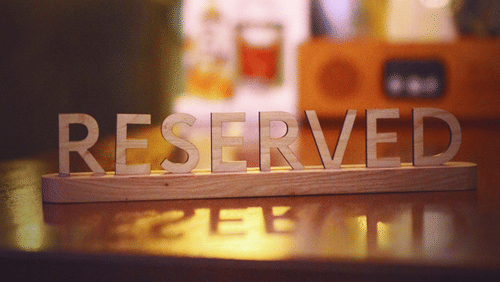 a board with the word reserved written on it kept on a table 