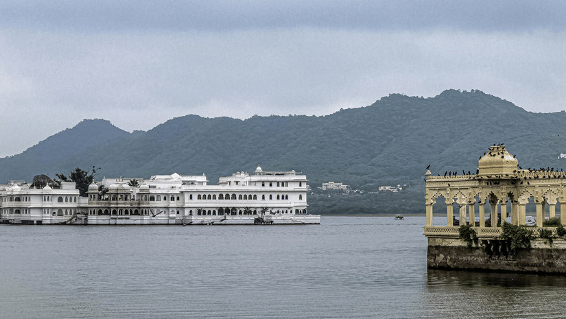 A view of Jal Mahal with the mountains in the backdrop on a cloudy day