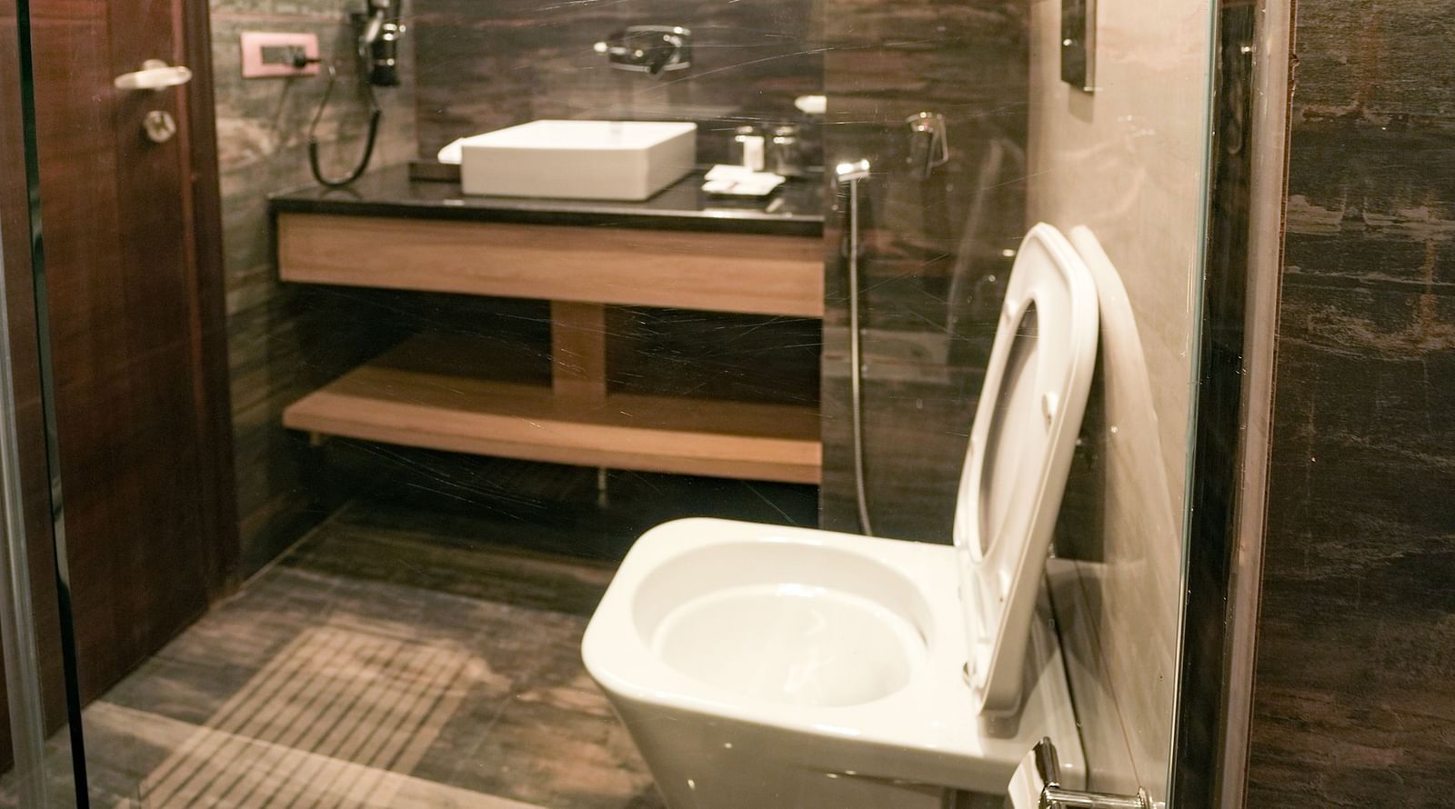 An image of an ambiently lit washroom that features toiletries, a commode and a large sink - NAMAMI BY ZENQ BANKHANDI
