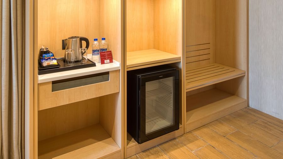 A cupboard at Executive Room at Le Foliage with a minibar and a tea and a coffee maker