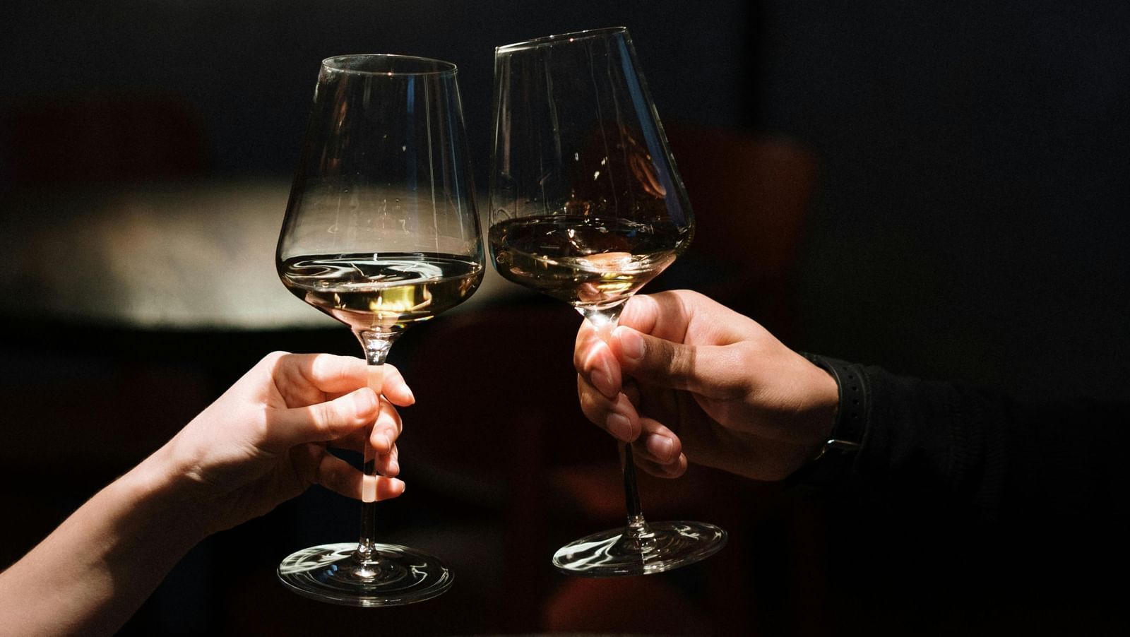 2 people clinking wine glasses.
