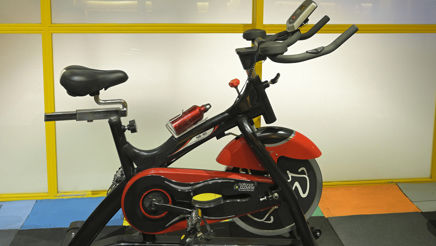 Stationary exercise bike positioned near the frosted glass wall at Hotel Sonar Bangla, Mayapur.